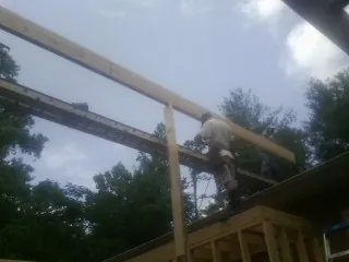 Carpenter setting a ridge beam over a new addition frame — Ice Dam Removal by Roofing Brothers in Nanty Glo