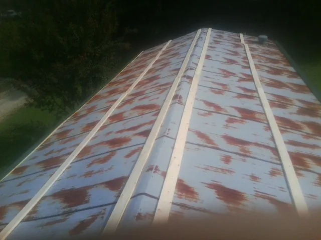 Rusted metal roof panels with new wood purlins before replacement — Storm Damage Roof Repair in Nanty Glo by Roofing Brothers