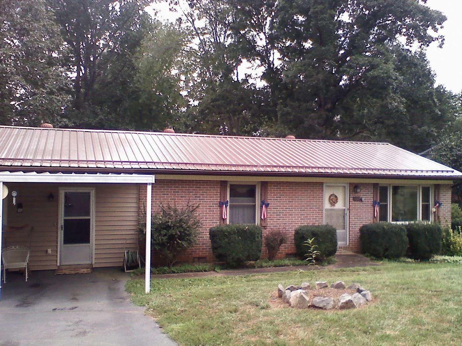 Bronze metal roof and carport on a brick ranch home — Roof Repair work by our crew in Nanty Glo